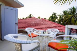 a patio with a table and chairs on a balcony at Elivaas Celest Luxe 4BHK Villa with Pvt Pool near Baga in Old Goa