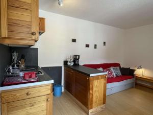 a kitchen with a red couch in a room at Appartement Saint-Chaffrey , 1 pièce, 4 personnes - FR-1-330E-49 in Serre Chevalier
