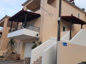 una casa con 2 balcones y una escalera delante de ella en Kanelli΄s apartments, en Monemvasia