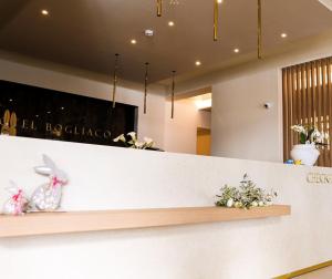 a lobby with a counter with flowers on it at Hotel Bogliaco in Gargnano