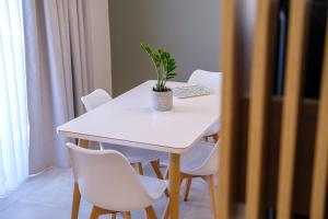 una mesa blanca con sillas blancas y una planta en ella en Olivo Home en Zipárion