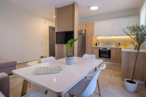 a kitchen and dining room with a white table and chairs at Olivo Home in Zipárion