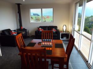 een woonkamer met een tafel en een bank bij Rocky Ridge Cottage in Takaka