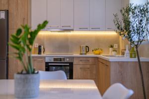 una cocina con armarios blancos y una mesa con una planta en Olivo Home en Zipárion