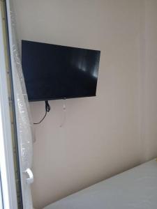 un téléviseur à écran plat accroché au mur dans l'établissement Apartment Aleksadra, à Paralia Katerinis