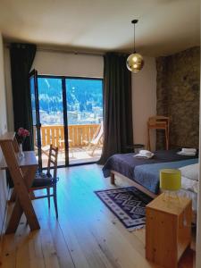 a bedroom with a bed and a view of a balcony at Hotel Lamish in Mestia