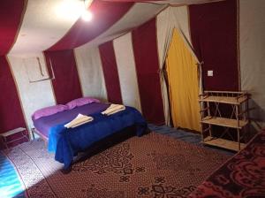a room with a bed and a tent at Bivouac Le charme d'Aladdin in El Gouera