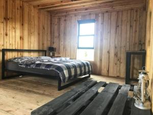a bedroom with a bed in a wooden cabin at Modern Barn Home & Sauna by the lake, przytulnastodola, Stodoła nad jeziorem na Mazurach in Ełk