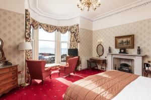 a hotel room with a bed and a fireplace at Fernhill Hotel in Portpatrick