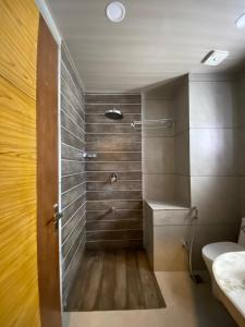 a bathroom with a shower with a toilet and a sink at Gulmarg Woods By Stay Pattern in Gulmarg