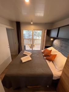um quarto com uma cama grande com duas toalhas em Mobile Home Bubamara em Drage