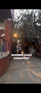 a sign that says business class dysfunction on a street at RDA Dormitory in Raipur