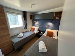 a small room with two beds and a window at Mobile Home Bubamara in Drage +46 photos