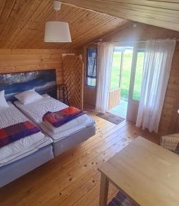 una camera con letto e tavolo in una cabina di Freja Vandrarhem a Vreta Kloster