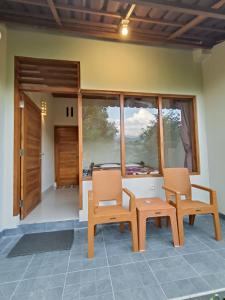 Habitación con 2 sillas, mesa y ventanas en Made Oka Budget Room, en Munduk