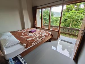 a bedroom with a bed and a large window at Made Oka Budget Room in Munduk