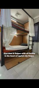 a bunk bed in a room with a sign on it at RDA Dormitory in Raipur