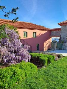 ein Haus mit einem lila Busch davor in der Unterkunft Quinta do Santinho in Amarante