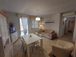 een keuken en een woonkamer met een witte tafel en stoelen bij the waterfront refuge - Il rifugio frontemare in Pietrasanta