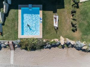 an overhead view of a swimming pool and a boat at Aquila Rithymna Beach in Adelianos Kampos