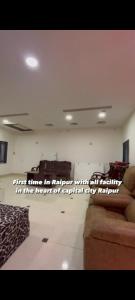 a living room with a couch and a quote on the wall at RDA Dormitory in Raipur