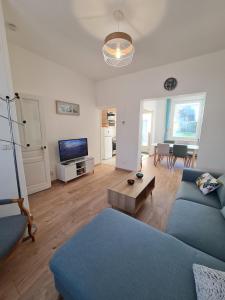 ein Wohnzimmer mit einem blauen Sofa und einem Tisch in der Unterkunft La ScarpeHouse - Douai - Wifi in Douai