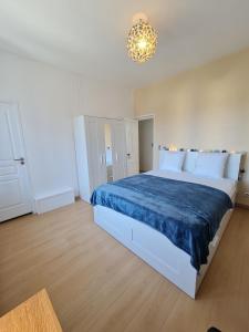 - une chambre avec un grand lit et une couverture bleue dans l'établissement La ScarpeHouse - Douai - Wifi, à Douai