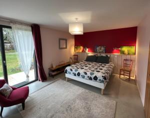 a bedroom with a bed and a large window at Relais de La Brande in Saint-Gourson