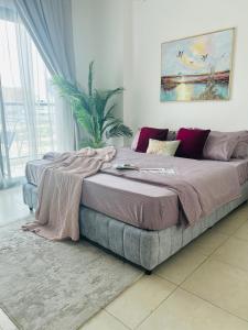 a bedroom with a large bed with a blanket on it at 1-Berdroom Apartment Rental Unit With Pool in Dubai Land Residence Complex in Dubai