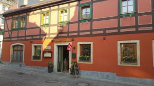 a orange building on the side of a street at Gasthaus& Pension Zum Roten Haus in Bad Schandau