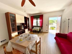 a living room with a table and a red couch at Residence Leonardo sul mare in Silvi Marina