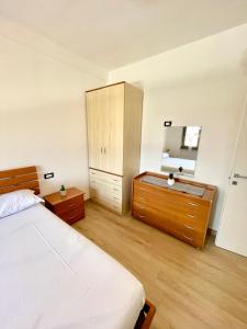 een slaapkamer met een bed, een ladekast en een spiegel bij Residence Leonardo sul mare in Silvi Marina