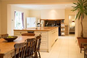 uma grande cozinha com uma mesa de madeira e um balcão em The Grange Manor House, Norfolk em Setchey