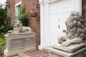 dwa kamienne posągi lwa na przedniej części domu w obiekcie The Grange Manor House, Norfolk w mieście Setchey