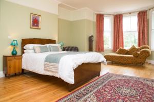 a bedroom with a large bed and a couch at The Grange Manor House, Norfolk in Setchey