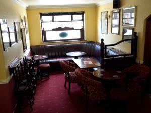 a restaurant with tables and a couch and a window at Bridge Hotel in Arklow