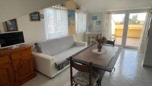 a living room with a couch and a table at La Mansarda in Biancareddu