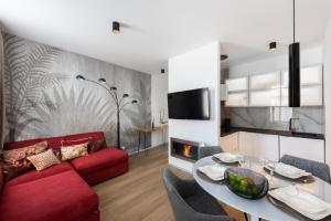 a living room with a red couch and a table at New modern apartment 5. floor in Prague