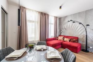 a living room with a table and a red couch at New modern apartment 5. floor in Prague