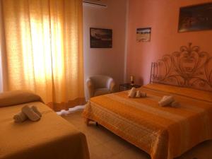 a bedroom with two beds with towels on them at Scilla A Vinedda in Scilla