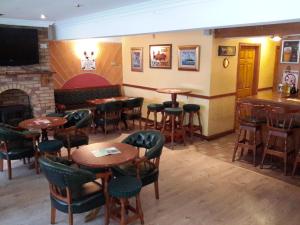 un restaurante con mesas y sillas y una chimenea en Bridge Hotel en Arklow