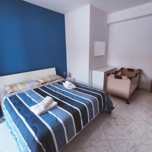 een blauwe slaapkamer met een bed met handdoeken erop bij Appartamento Rosariomaria in Realmonte