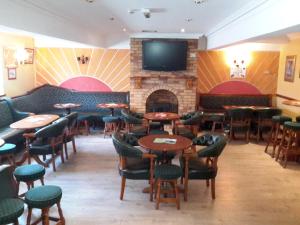 a restaurant with tables and chairs and a fireplace at Bridge Hotel in Arklow