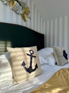 a pillow with an anchor on it sitting on a bed at Karwia Plaza - Apartments - Domki z basenem, jacuzzi i sauną in Karwia