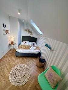 カルビアにあるKarwia Plaza - Apartments - Domki z basenem, jacuzzi i saunąのベッドルーム1室(ベッド1台、緑の椅子付)