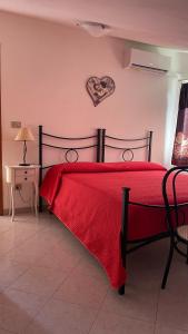 BiancaredduにあるLa Mansardaのベッドルーム1室(壁にハートを掛けた赤いベッド1台付)