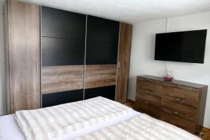 a bedroom with a bed and a dresser with a television at Villa Sorgenfrei in Reutte