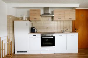 a kitchen with white cabinets and an oven at Villa Sorgenfrei in Reutte