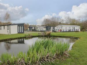 a row of mobile homes next to a pond at Yealand 36 in Carnforth