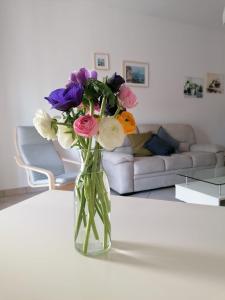 un jarrón de flores sobre una mesa en la sala de estar en A Casa Scipione, en Formia